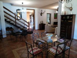 - un salon avec une table et des chaises ainsi qu'un escalier dans l'établissement CASA RURAL LA CABRA DEL MEDIO, à Monesterio