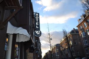 een bord voor een winkel in een stadsstraat bij Aadam Hotel Wilhelmina in Amsterdam