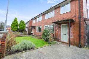 a brick house with a green door and a yard at Calming and Serene 2 BR Getaway in Worsley