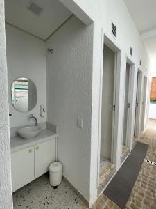 een witte badkamer met een wastafel en een spiegel bij Morada City Hostel in Sao Paulo