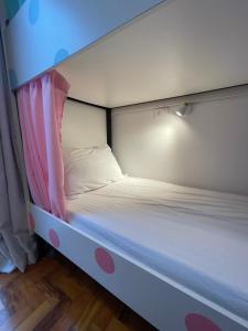 een wit bed met een roze baldakijn in een kamer bij Morada City Hostel in Sao Paulo