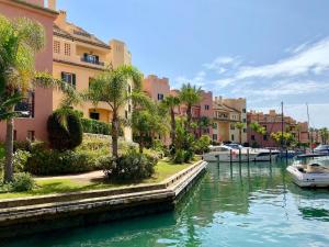 un canal dans une ville avec des maisons et un bateau dans l'établissement San Roque Golf Club, Step into elegance with this 3-bedroom luxury modern townhouse close to Sotogrande, à San Roque
