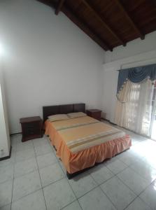 1 dormitorio con 1 cama en la esquina de una habitación en Posada de Zory, en Santo Domingo de los Colorados