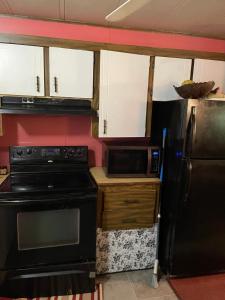 a kitchen with a black stove and a refrigerator at Air b/b lodge in Windsor