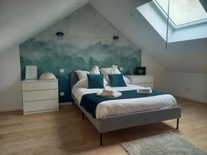 a bedroom with a large bed with blue pillows at Maison de ville in Bouguenais