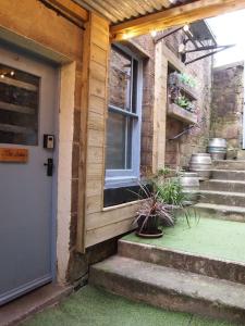 a front door of a house with stairs and a window at The Snug in Matlock