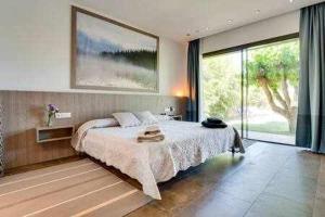 um quarto com uma cama grande e uma janela grande em Villa Falguerar em Llofríu