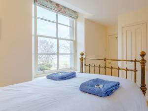2 toallas en una cama en un dormitorio con ventana en 3 bed in Achnasheen CA120, en Inveralligin