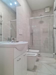 a bathroom with a toilet and a sink and a shower at ATTICO GENOVA con POSTO AUTO in Genova