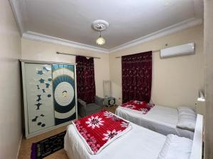ein Schlafzimmer mit 2 Betten und einem Wandgemälde in der Unterkunft Pyramids Sunrise in Kairo