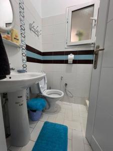 een badkamer met een toilet, een wastafel en een raam bij Cosy studio jardin de l’aouina in Tunis