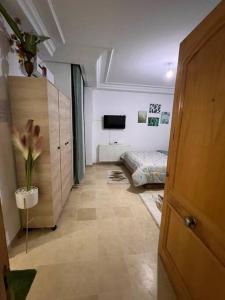 a room with a bedroom with a bed and a door at Cosy studio jardin de l’aouina in Tunis
