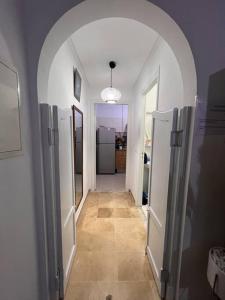 a hallway with an archway in a room with a kitchen at Cosy studio jardin de l’aouina in Tunis