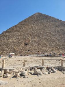 Eine Pyramide mit einer Menschenmenge davor in der Unterkunft Pyramids Sunrise in Kairo