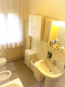 La salle de bains est pourvue de toilettes blanches et d'un lavabo. dans l'établissement Ca' Trevisetto - Casa Vacanze, à Monastier di Treviso