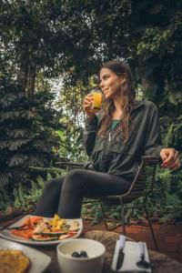 a woman sitting in a chair drinking a drink at Montana Posada in Roldanillo