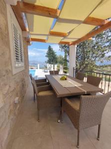 een eettafel en stoelen op een patio bij Villa Bob in Povlja