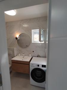 een badkamer met een wasmachine en een wastafel bij Villa Bob in Povlja