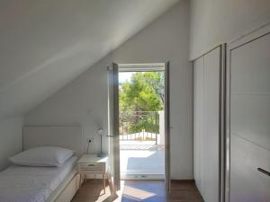 een slaapkamer met een bed en een deur naar een patio bij Villa Bob in Povlja