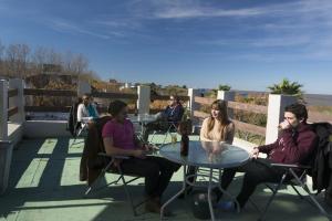 un groupe de personnes assises à une table sur un patio dans l'établissement Viajero Posada B&B, à Colonia del Sacramento