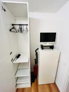een kamer met een computer bovenop een koelkast bij Apartment LEO in Berghausen