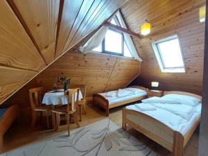 スロモフツェ・ビジネにあるWilla Przekop - apartamentyのベッド2台とテーブルが備わるキャビンです。
