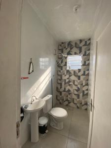 uma casa de banho branca com um WC e um lavatório em Xixová Hostel em São Vicente