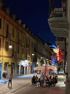 een groep mensen die 's nachts op straat zitten bij MonferraTO: tutto a due passi in Turijn