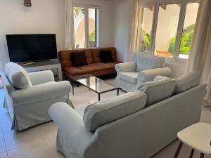 a living room with couches and a flat screen tv at Villa Cecylia in Es Canutells