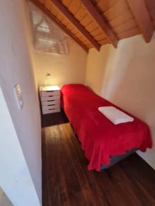 1 dormitorio con cama roja y manta roja en Cabañas Mi Lugar en Las Gaviotas