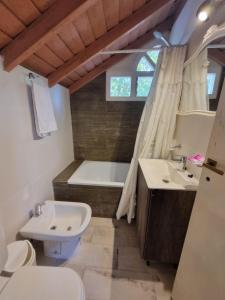 uma casa de banho com um WC, um lavatório e uma banheira em Cabañas Mi Lugar em Las Gaviotas