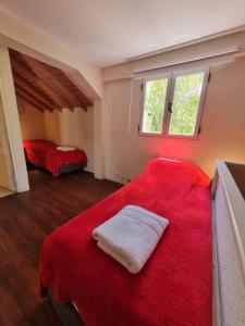 1 dormitorio con 2 camas y manta roja en Cabañas Mi Lugar en Las Gaviotas