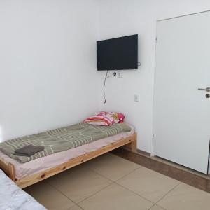 a bed in a room with a tv on a wall at noclegi na wsi ,,Ania,, in Okszów