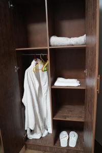 a wooden closet with towels and towels and shoes at New Cairo Huazhuyijia-华住驿家 in Cairo