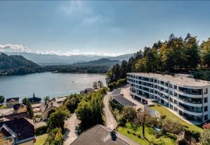 an aerial view of a building next to a lake at Top 9 Alpe Maritima - Lakeview Apartment mit Bergkulisse in Annenheim