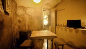 een kamer met een tafel en twee banken en een televisie bij Studio Mazo La Cuevita in Mazo