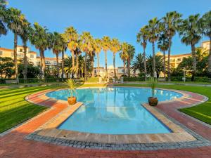 a swimming pool with palm trees in a park at Peaceful Retreat, Pools, Gym, Parks in Cape Town