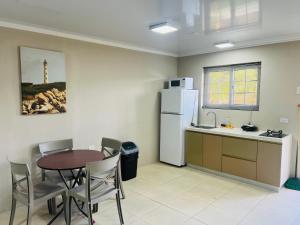 uma cozinha com uma mesa e um frigorífico branco em The Gold Vacation Apartments em Santa Cruz