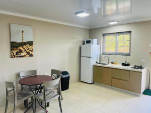 a kitchen with a table and a white refrigerator at The Gold Vacation Apartments in Santa Cruz