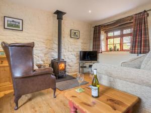a living room with a couch and a wood stove at 1 Bed in Eden Valley SZ237 in Kirkoswald