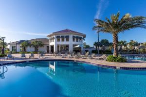 einen Pool mit Stühlen und ein Haus in der Unterkunft Luxury Lake View 9-Bedroom Villa @Storey Lake Resort in Kissimmee