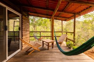 een hangmat en stoelen op een veranda van een hut bij Yoo'Nashi - Estancia Ecológica y Experiencias Comunitarias in Santa María Huatulco