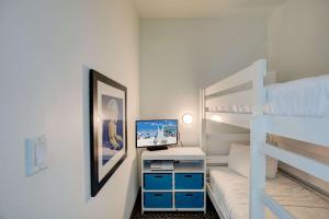 1 dormitorio con litera y escritorio con ordenador en Best Western Premier - The Tides, en Orange Beach