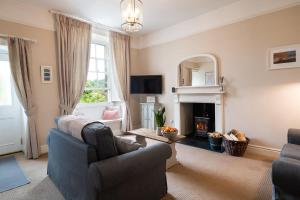 a living room with two chairs and a fireplace at Pendle View Apartment in Settle