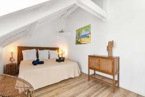 1 dormitorio blanco con 1 cama y suelo de madera en Sur la plage de la Baie Orientale - Bel appartement VUE MER 6à7p, en Orient Bay 30 fotos más