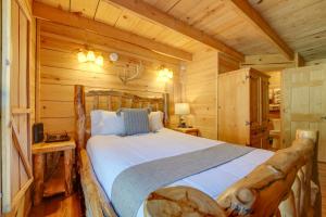 1 dormitorio con 1 cama en una cabaña de madera en Branson Antlers Lodge Cabin with Private Hot Tub en Branson