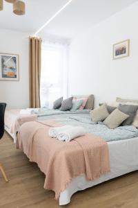 2 łóżka w białym pokoju z ręcznikami w obiekcie C85 Apartament Juliett w mieście Lublin