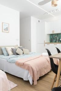 biała sypialnia z łóżkiem z różowym kocem w obiekcie C85 Apartament Juliett w mieście Lublin