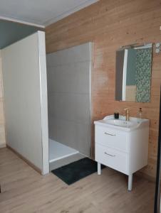 y baño con lavabo blanco y espejo. en Alternative hôtel, 