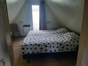 a bedroom with a bed with a black and white comforter at Stijlvol aan de visvijver in Gramsbergen +30 photos